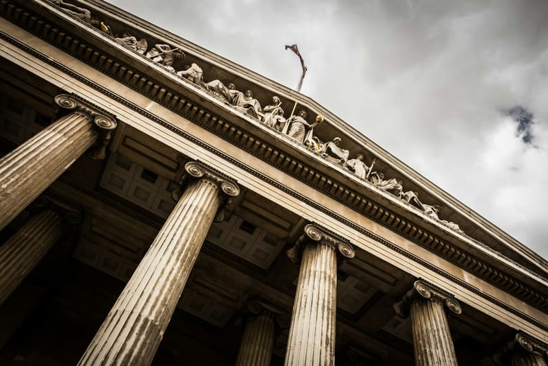 Stone columns and carved pediment of a neoclassical courthouse